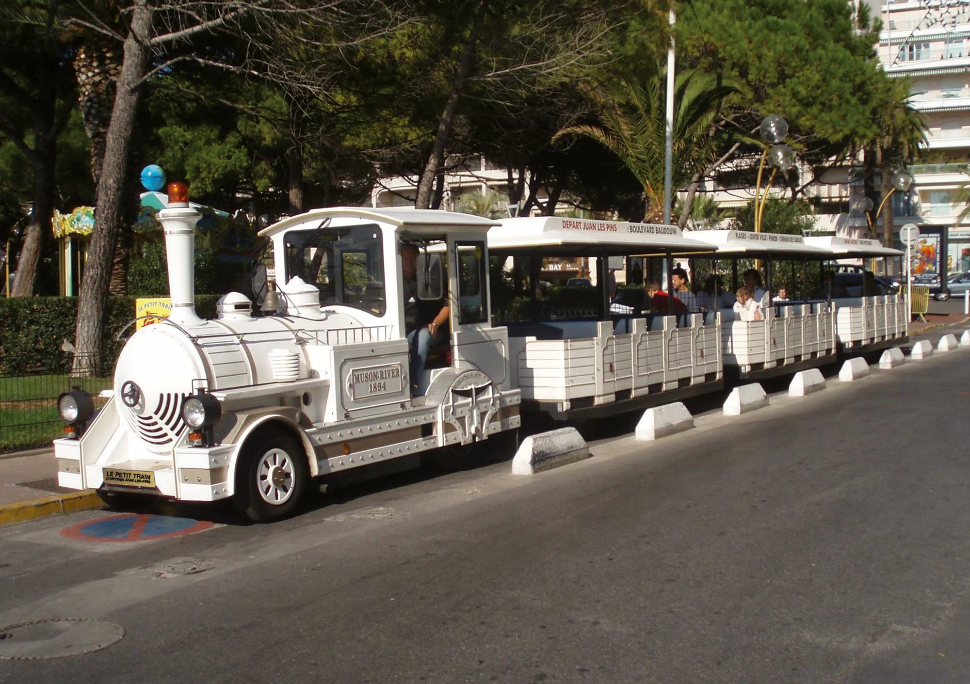 Le Petit Train blanc à l’arrêt sous les pins, au départ de Juan-les-Pins