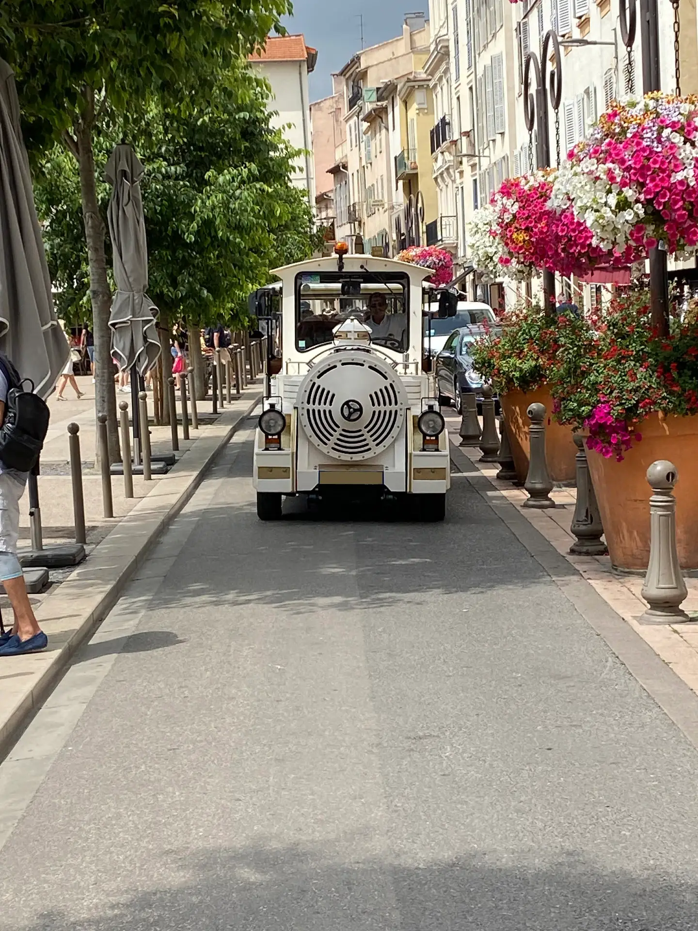 The Petit Train seen from the front in a flower-lined street of old Antibes