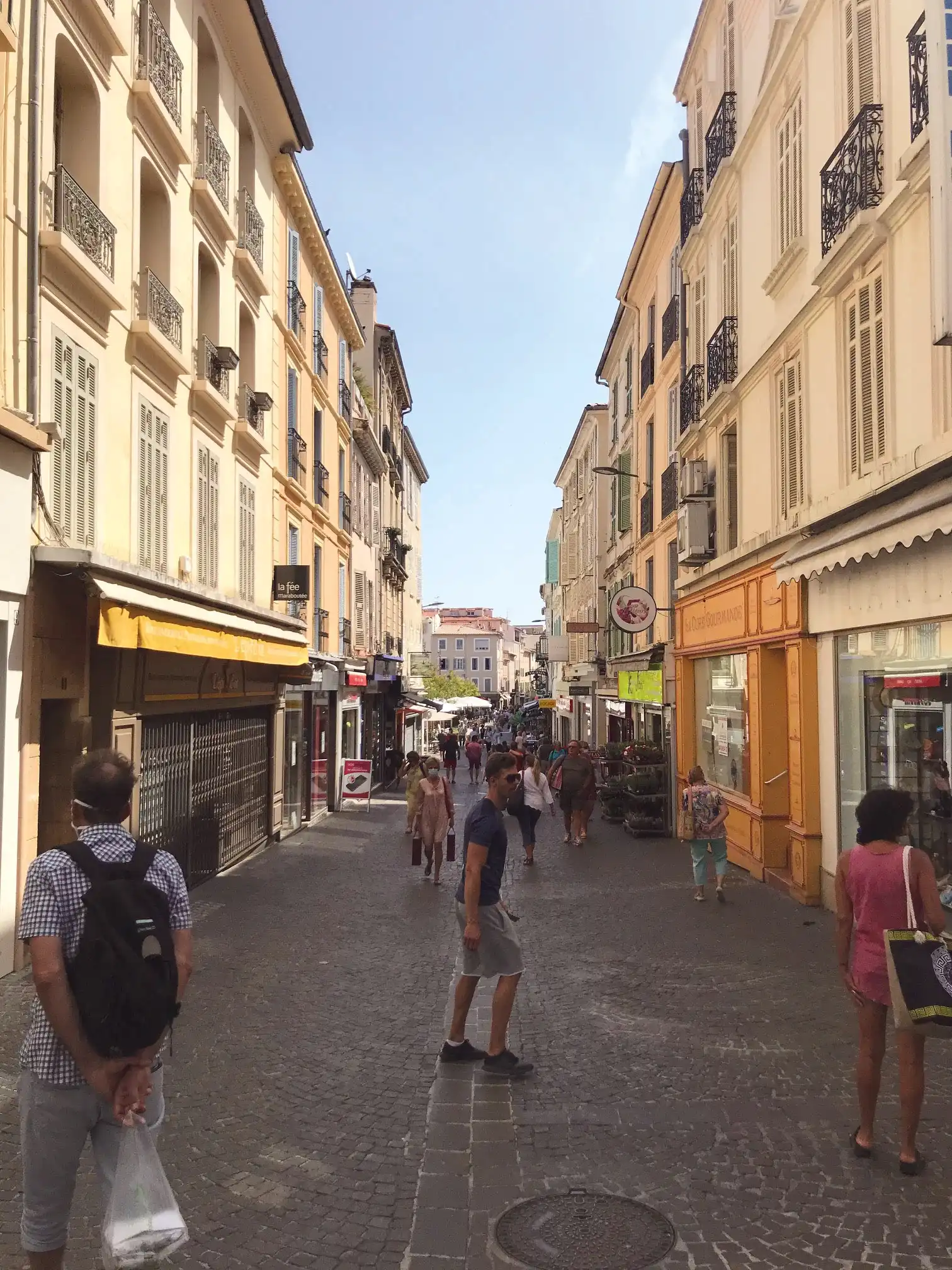 Pedestrian street in the old town of Antibes with passers-by